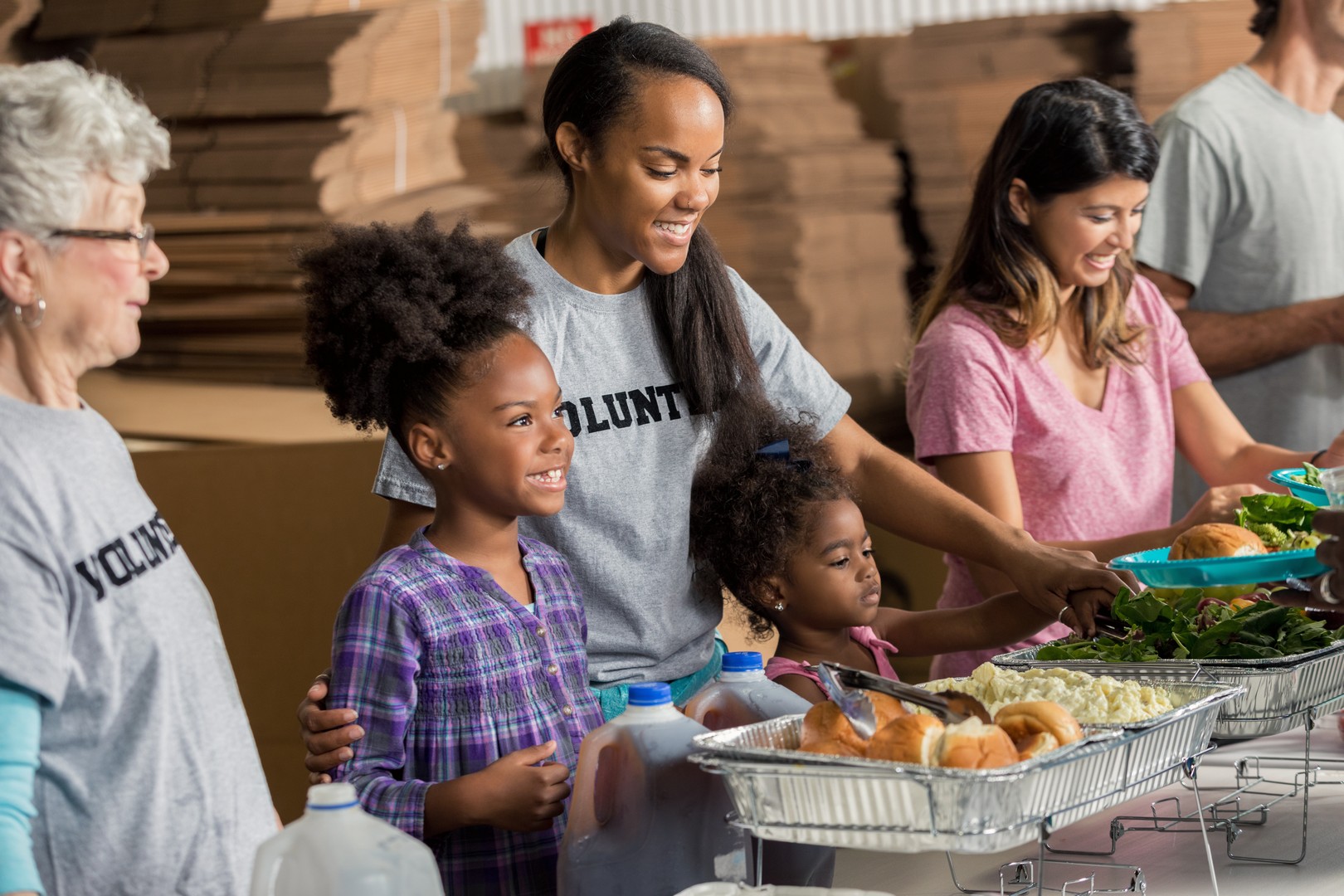 Diverse family volunteers together in soup kitchen Webster United